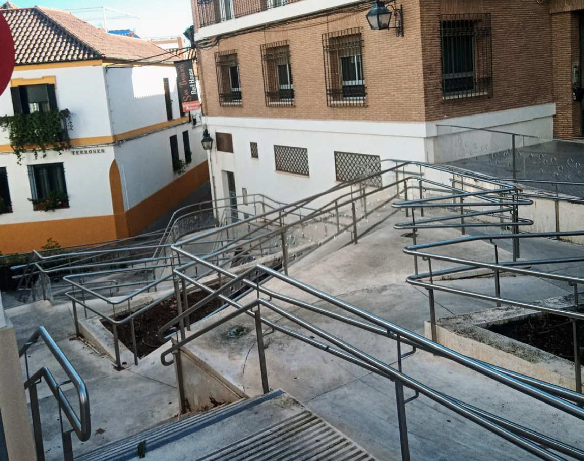 Complex network of ramps and railings outside buildings, designed for wheelchair accessibility