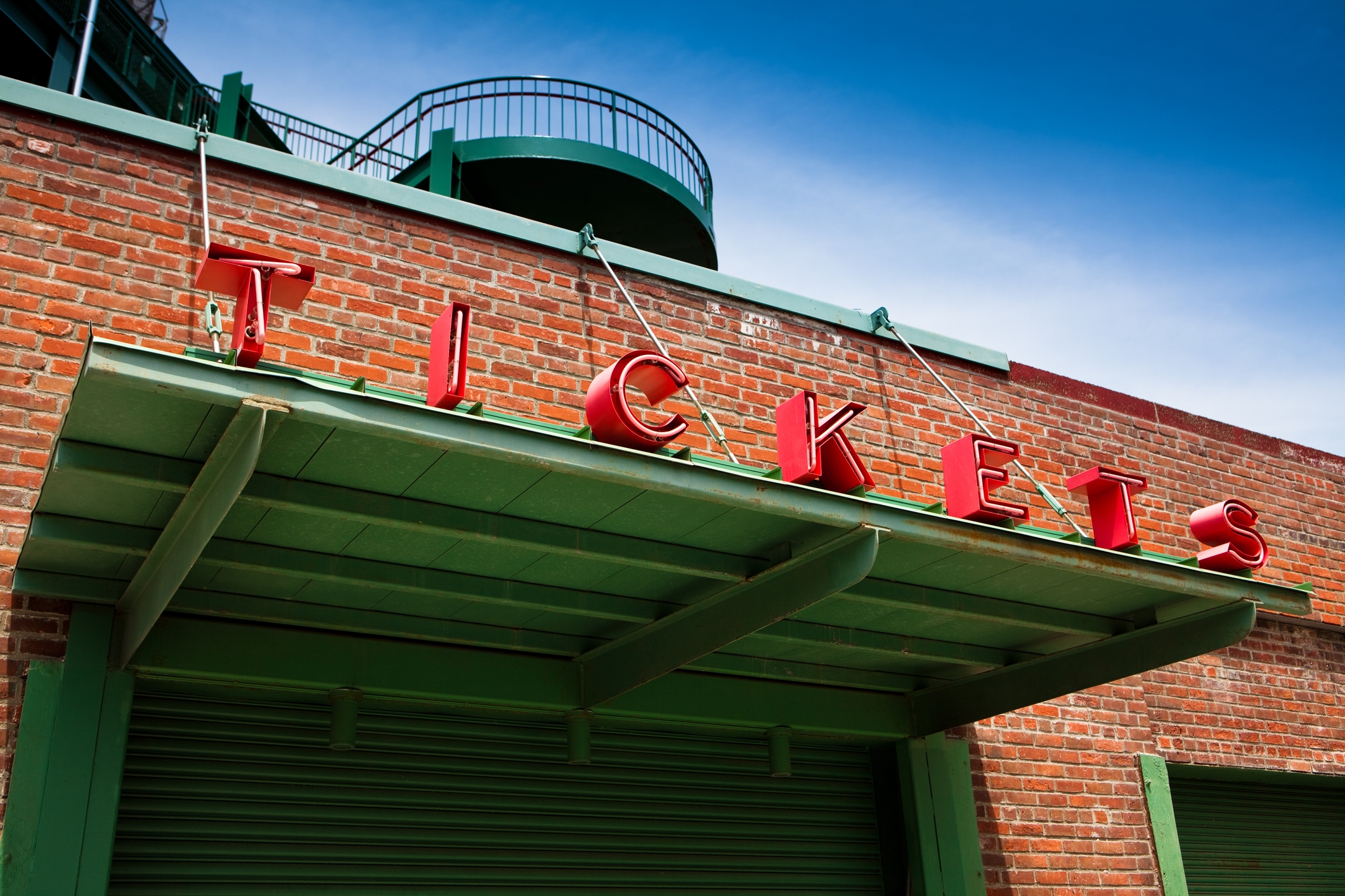 Brick building with large "TICKETS" sign above a green awning, suggesting a ticket booth or sales location