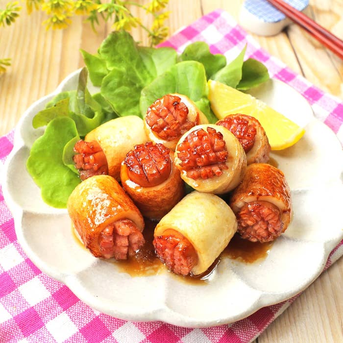 ちくわにウインナーを詰めた照り焼き味の料理が、レタスとレモンのスライスと一緒に白い皿に盛り付けられている。
