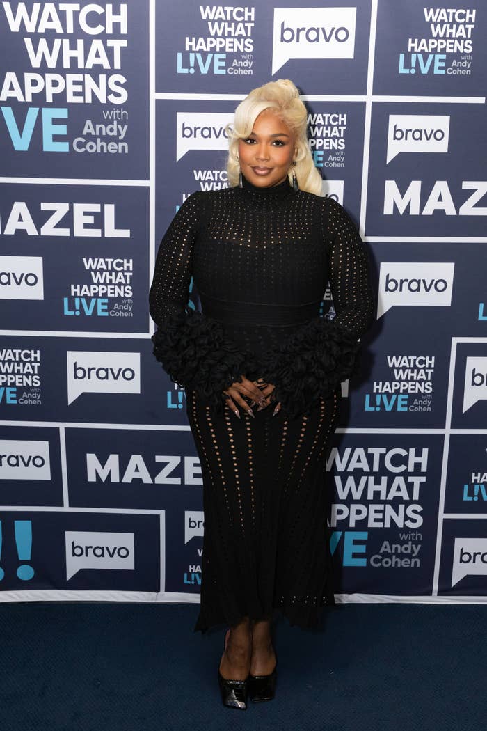 Lizzo successful a fitted achromatic formal with a signifier and voluminous sleeves poses successful beforehand of a "Watch What Happens Live" step-and-repeat wall