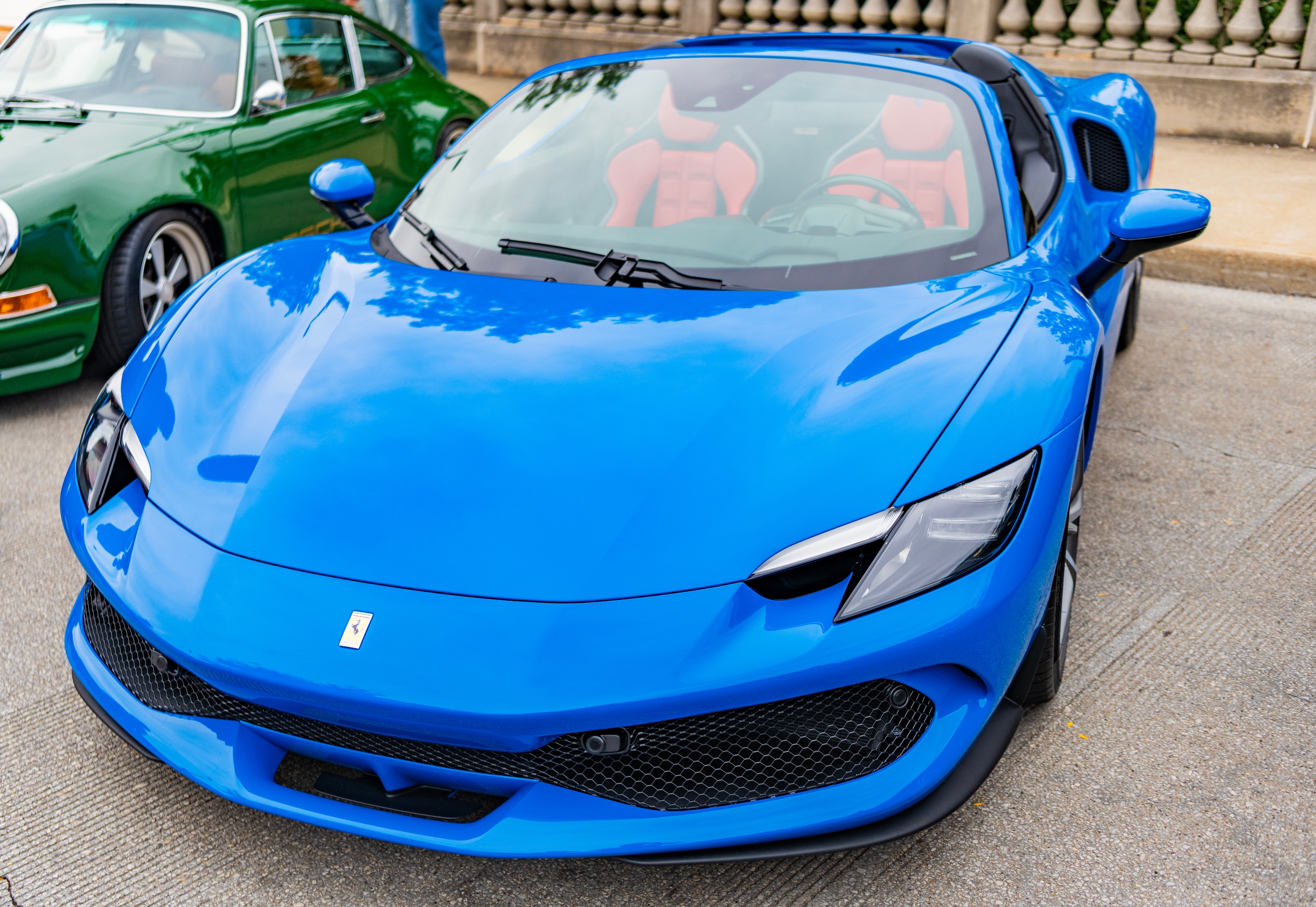 A glossy blue Ferrari parked on a street
