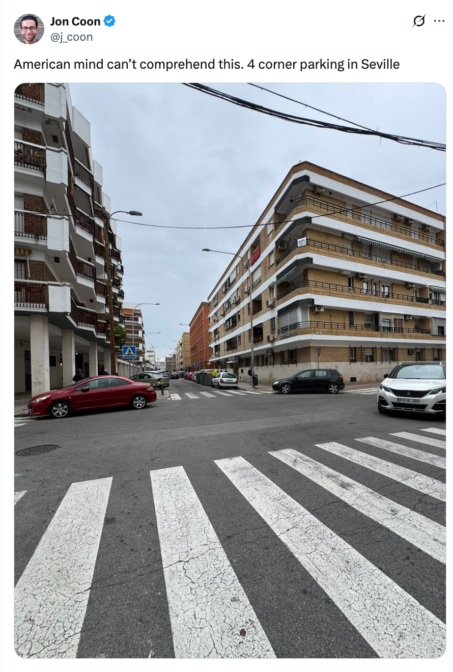 Street intersection in Seville with cars parked at four corners, highlighting a unique urban parking arrangement