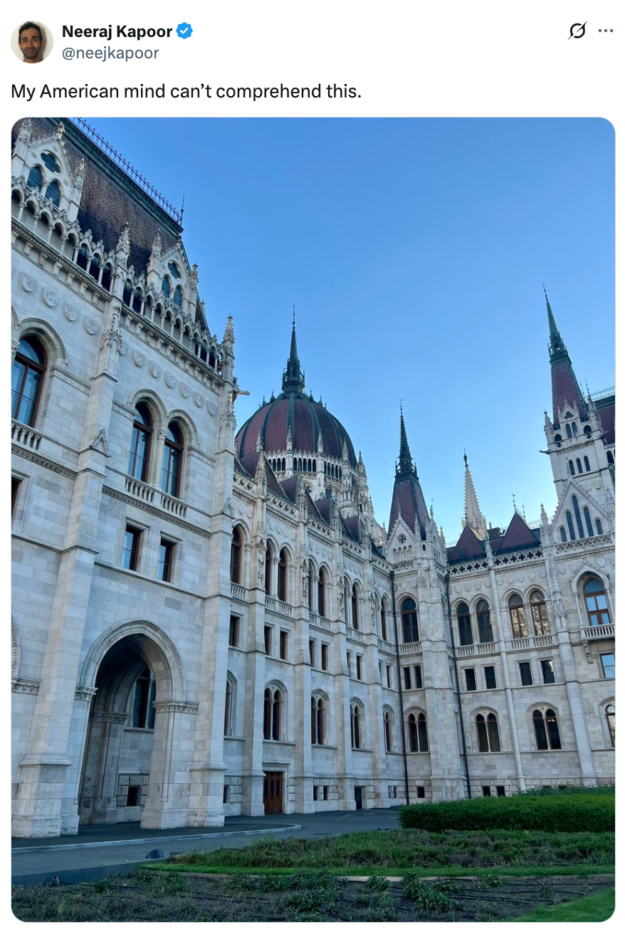 A gothic-style building with intricate details and sharp spires. Tweet reads: "My American mind can’t comprehend this."