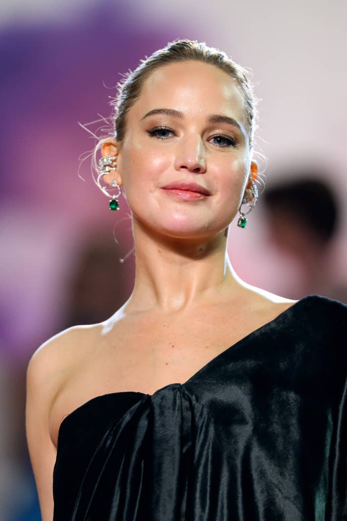 Jennifer Lawrence at an event in an elegant one-shoulder gown with statement earrings