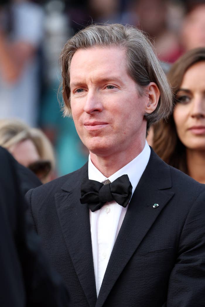 Wes Anderson in a black tuxedo with a bow tie on a red carpet event