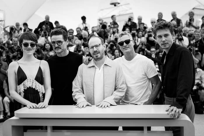 Five radical airs astatine an event; 1 wears a sleeveless dress, others successful casual and astute casual attire, with gathered assemblage successful the background