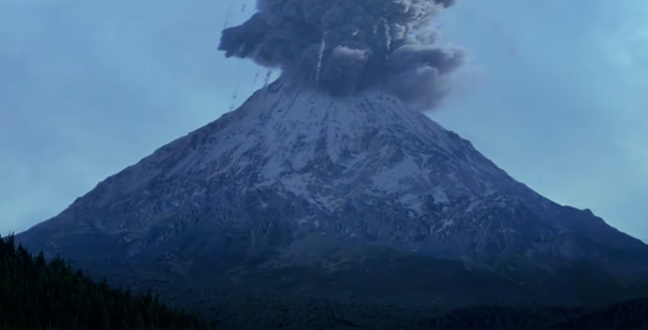 A volcano erupts with dark smoke and ash billowing into the sky