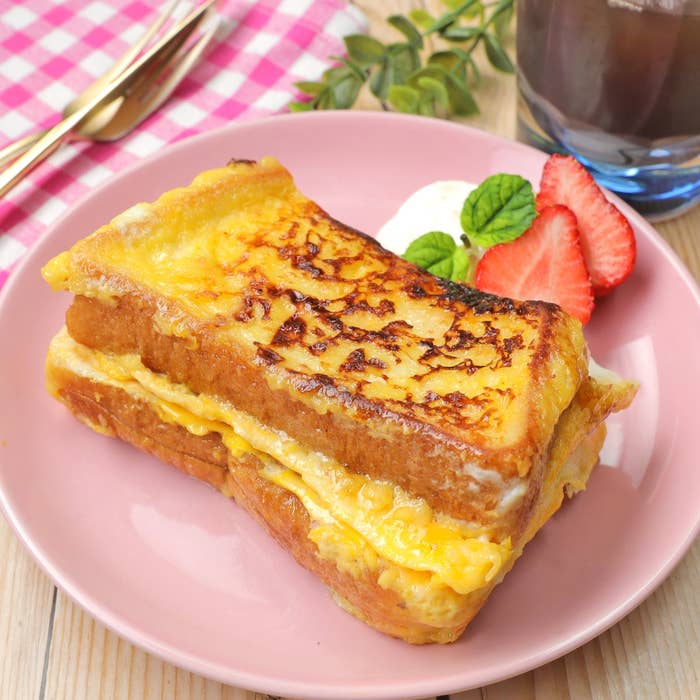 フレンチトーストが置かれ、横にいちごとクリームが添えられたプレート。