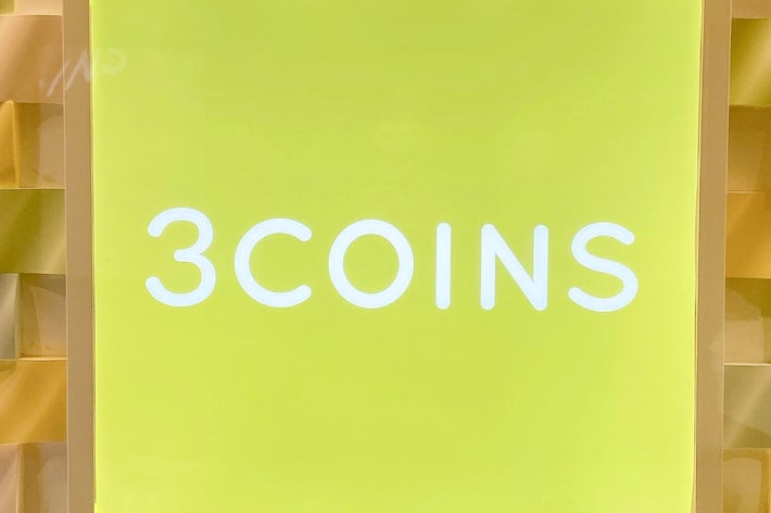 3COINSの明るいサインが立体的な壁面に表示されている。店舗の装飾が特徴的。