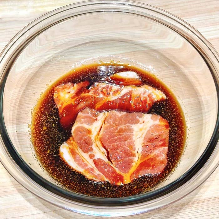 ガラスボウルに入った肉がマリネ液に浸かっている。