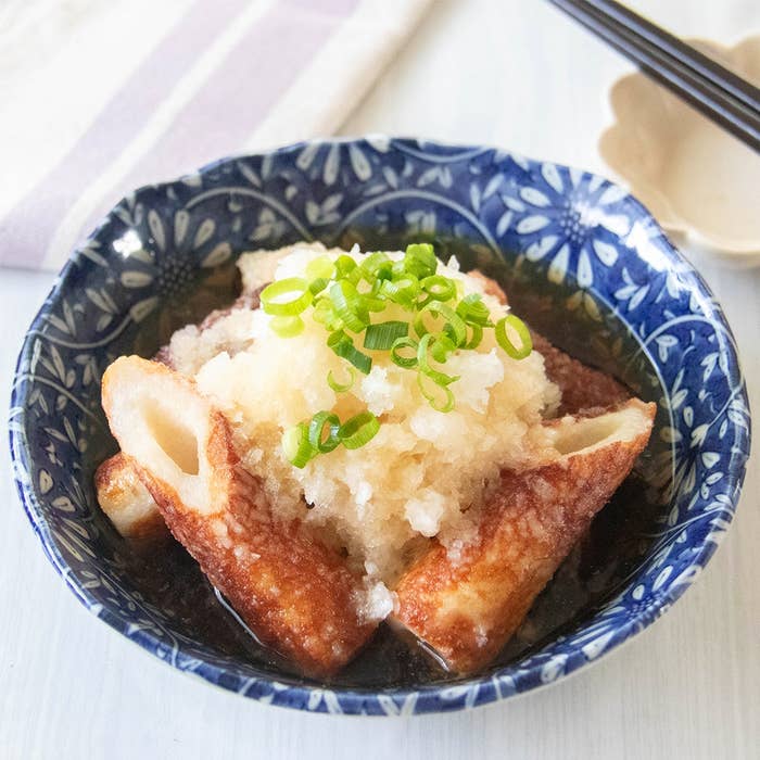 青い模様の器に入ったちくわの揚げ出しと大根おろし、刻んだネギの盛り付け。