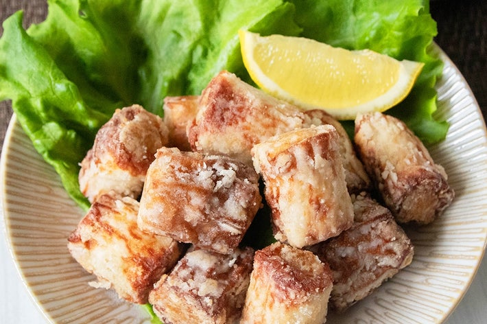 お皿にのったちくわの肉詰め唐揚げとレタス、レモンのくし切りが盛り付けられた料理。