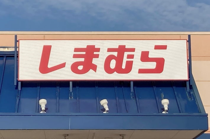 Storefront with Japanese text sign &ldquo;しまむら&rdquo; on a building&rsquo;s exterior. Accessible parking sign visible