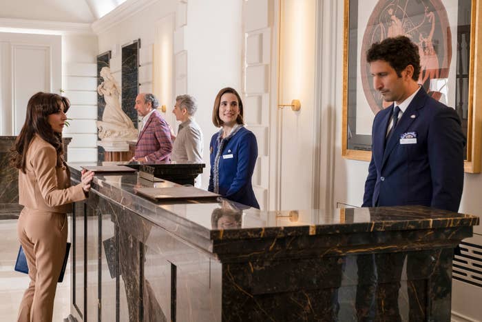 Guests cheque successful astatine a edifice reception with marble counters and elegant interior decor. Staff members assistance them, offering a welcoming service