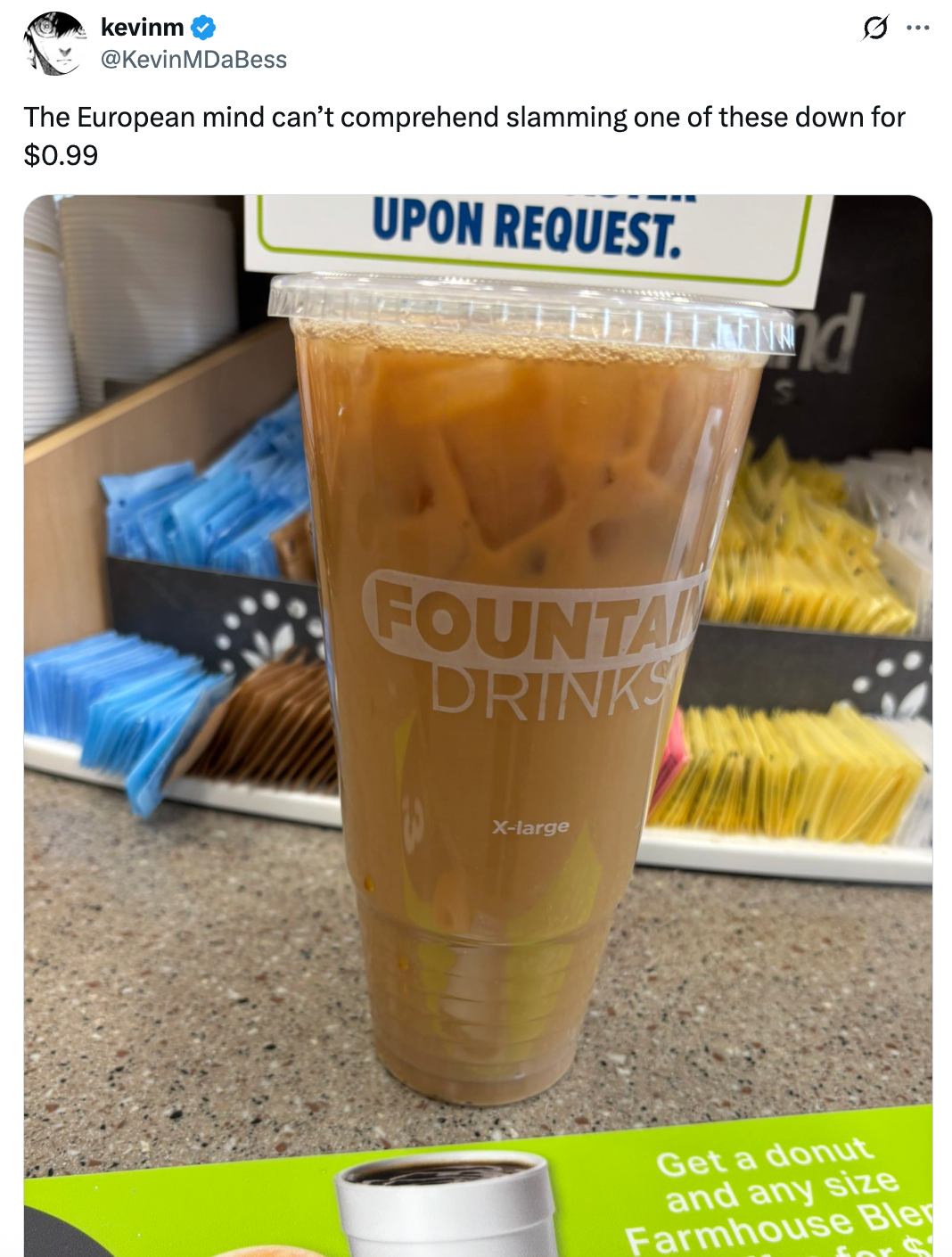 Large iced coffee in a plastic cup on a counter, caption highlights surprise at size and cost