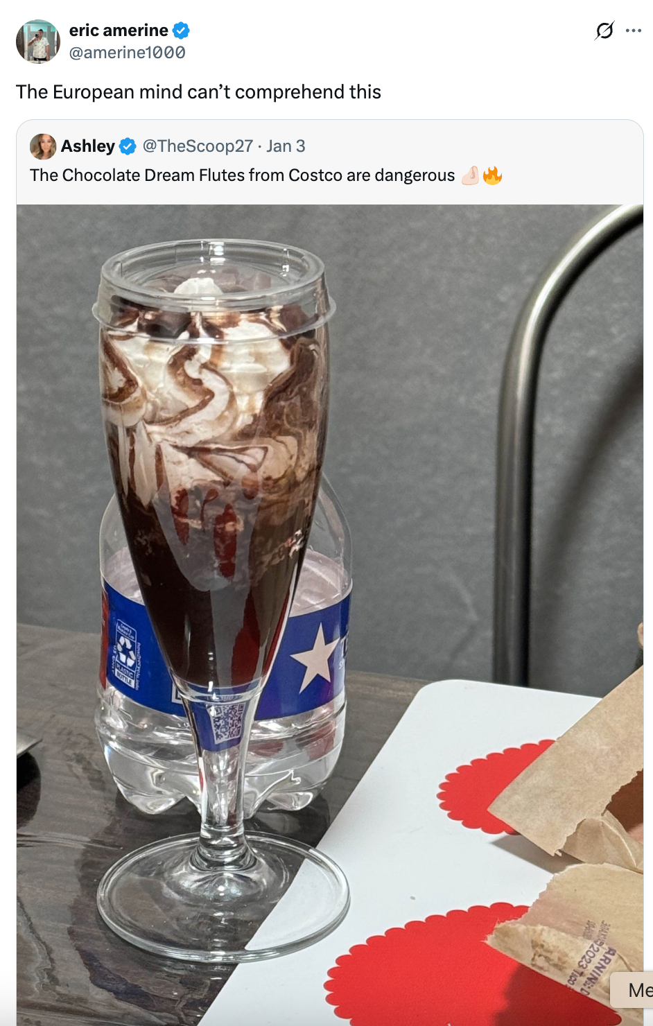 Glass filled with chocolate syrup and whipped cream beside a bottled water and a red tray with food wrapping. Caption jokes about Costco dessert