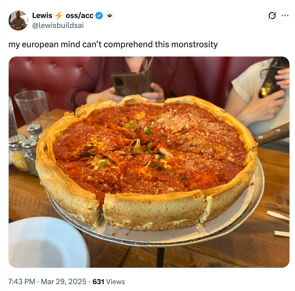 Deep-dish pizza with a thick crust and rich tomato sauce, garnished with vegetables, served at a restaurant