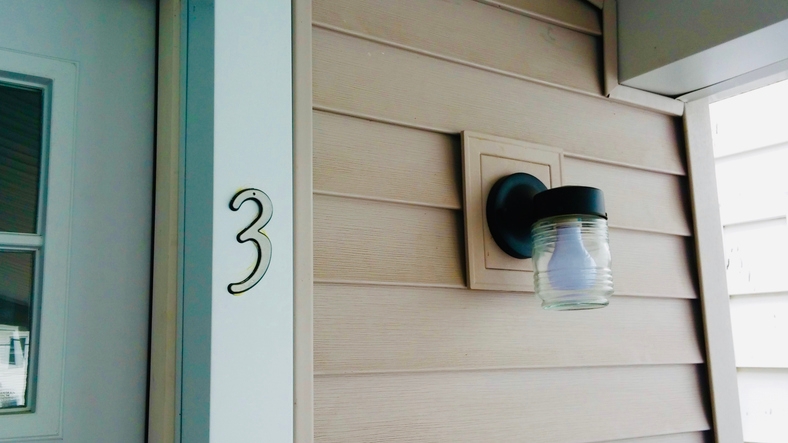 House exterior with number 3, porch light, and siding