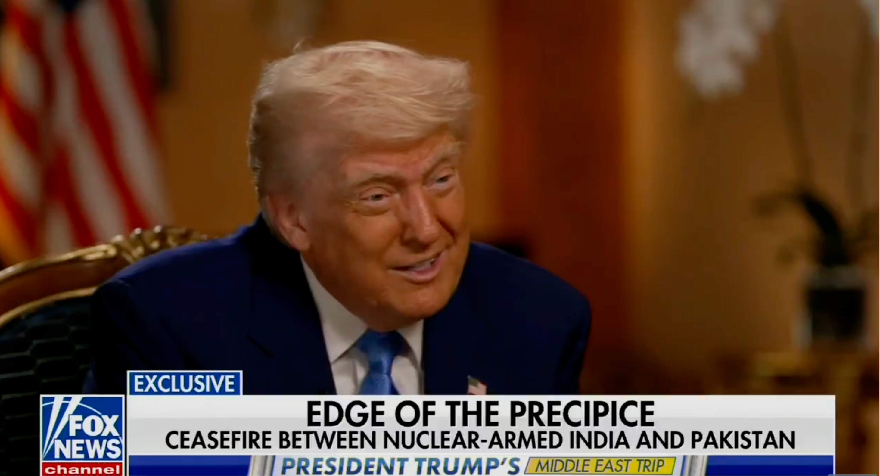 A man in a suit is interviewed on a news channel. The headline discusses a ceasefire between nuclear-armed India and Pakistan
