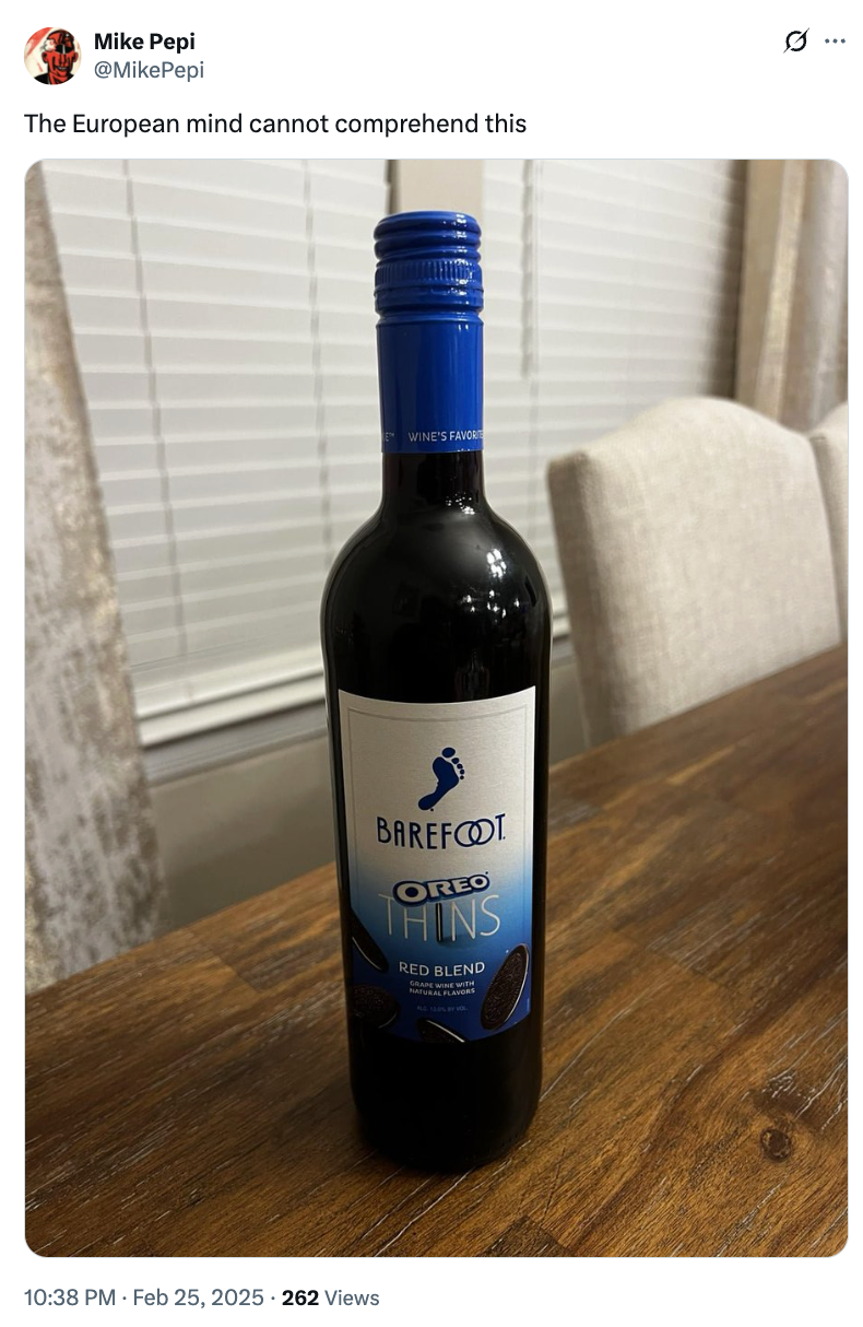 A bottle of Barefoot wine with "Oreo Thins Red Blend" on the label, placed on a wooden table. Tweet reads: "The European mind cannot comprehend this."