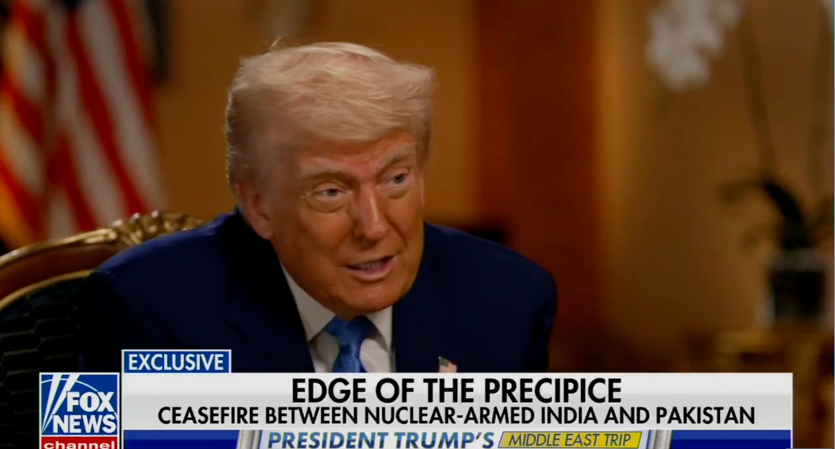A man is seated, speaking during a televised interview. A news headline below discusses a ceasefire between nuclear-armed India and Pakistan