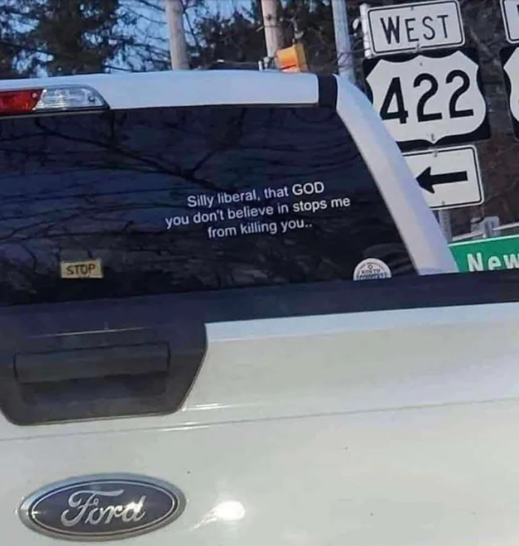 Bumper sticker on a truck reads: "Silly liberal, that GOD you don't believe in stops me from killing you…" near highway signs for West 422