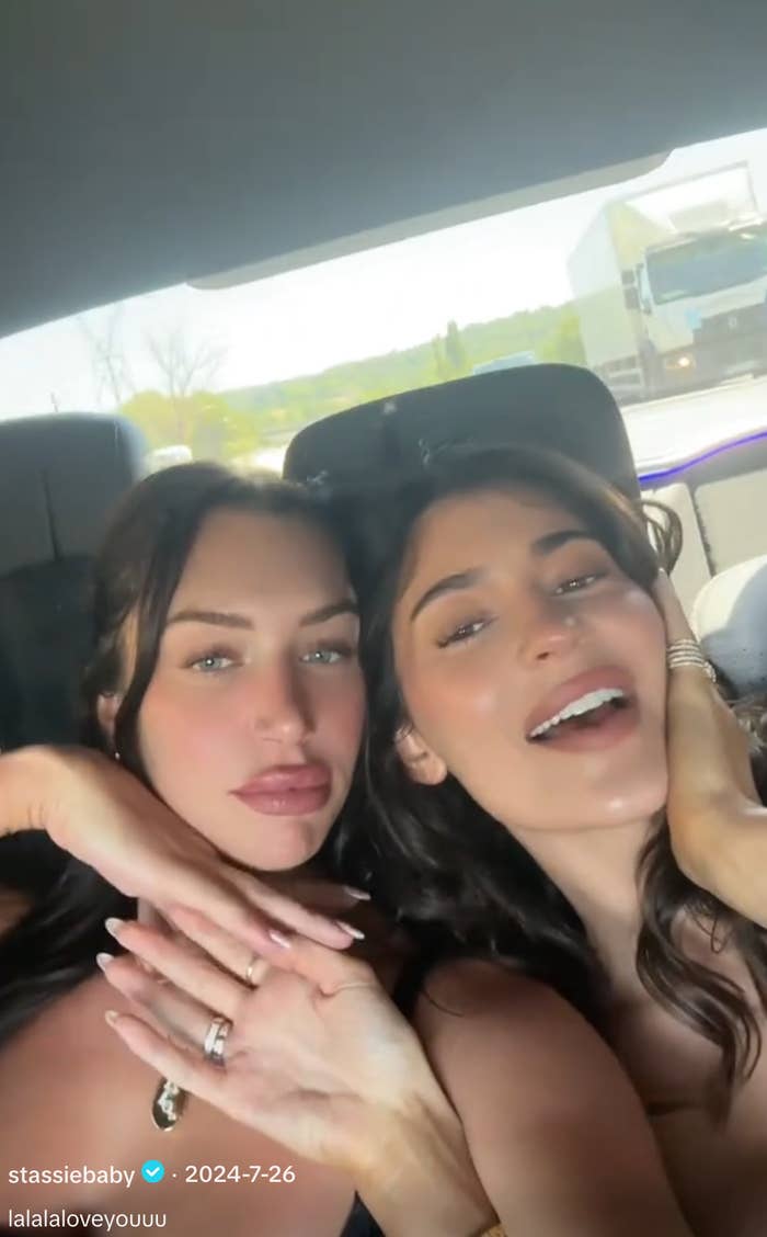 Two radical smiling wrong a car, posing for a selfie with relaxed expressions