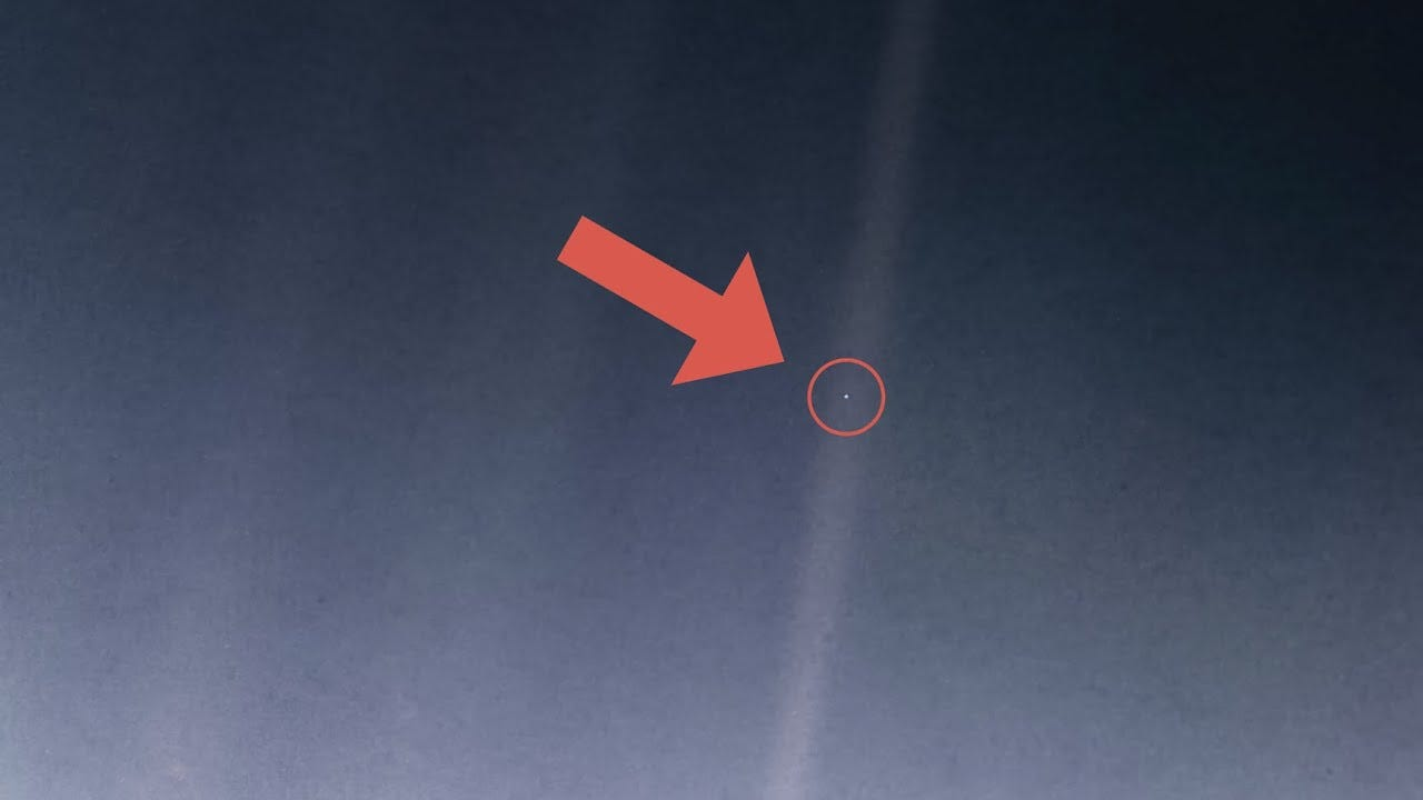 Space image with a red arrow pointing to a small speck labeled as Earth, highlighting its tiny appearance from a vast distance