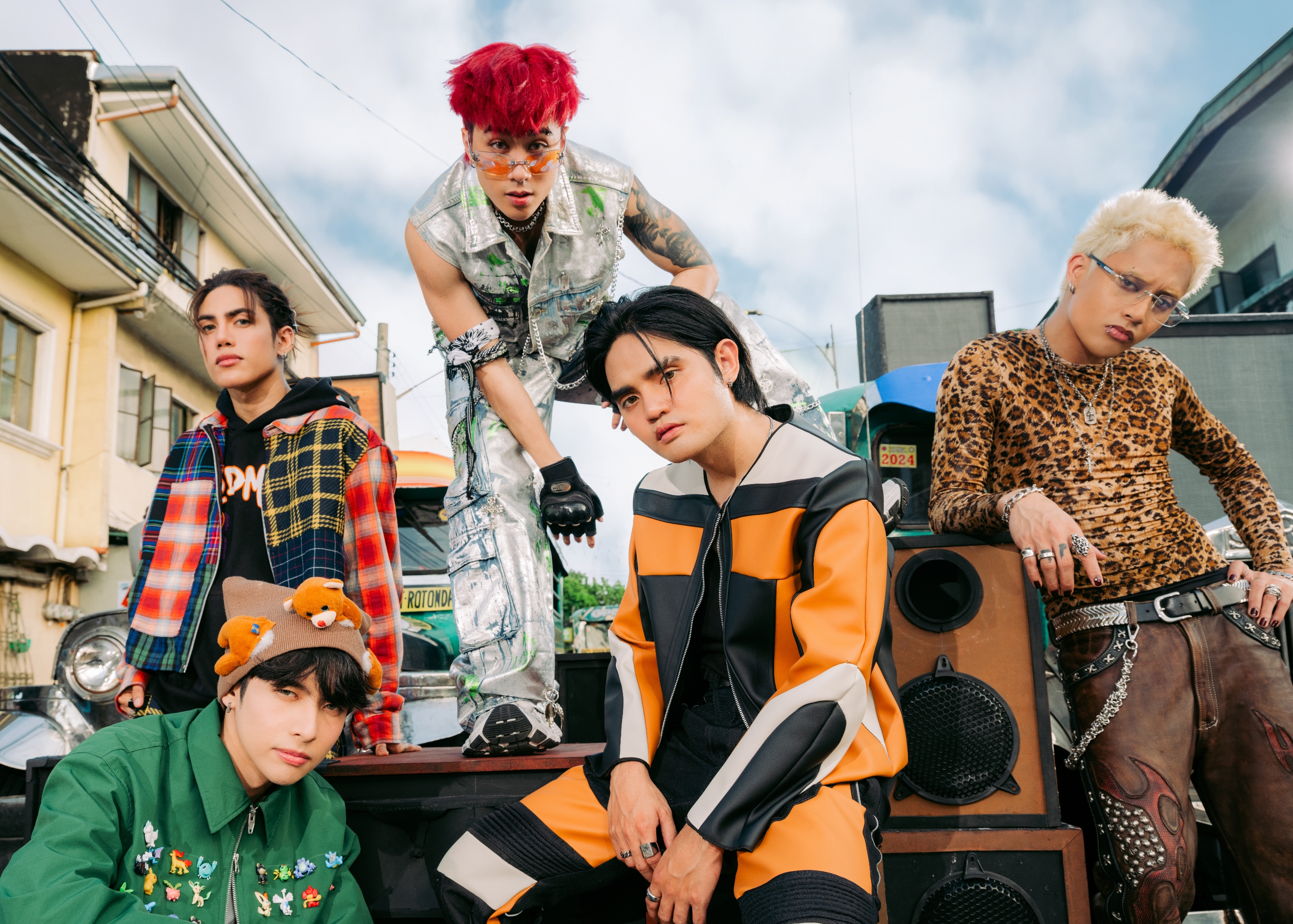 Five individuals in eclectic streetwear pose outdoors, showcasing diverse styles with vibrant and patterned outfits