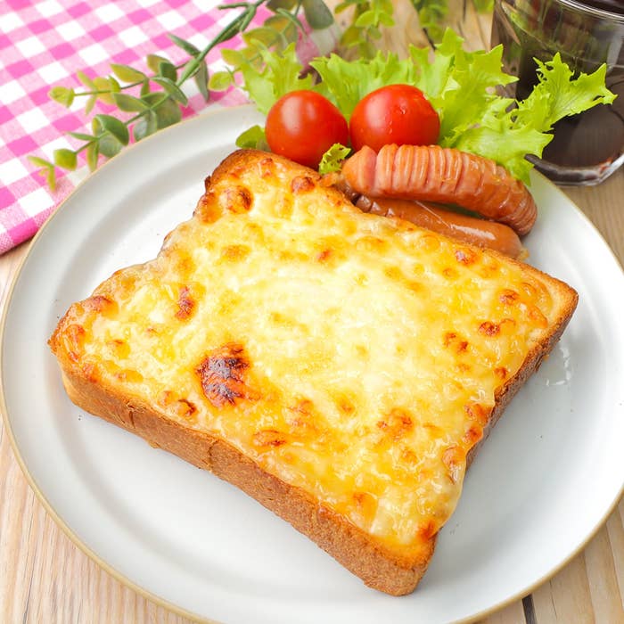 トースト、トマト、レタス、ソーセージが皿に盛られている食事シーン。