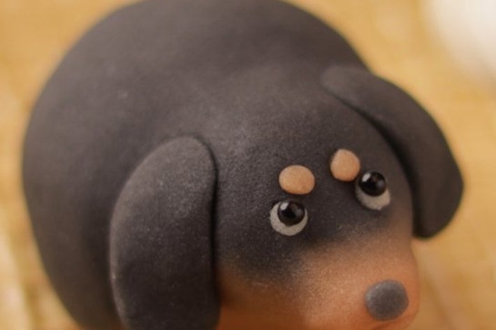 ユニークな犬の形をしたスイーツがプレートに添えられ、クリームが隣に置かれています。