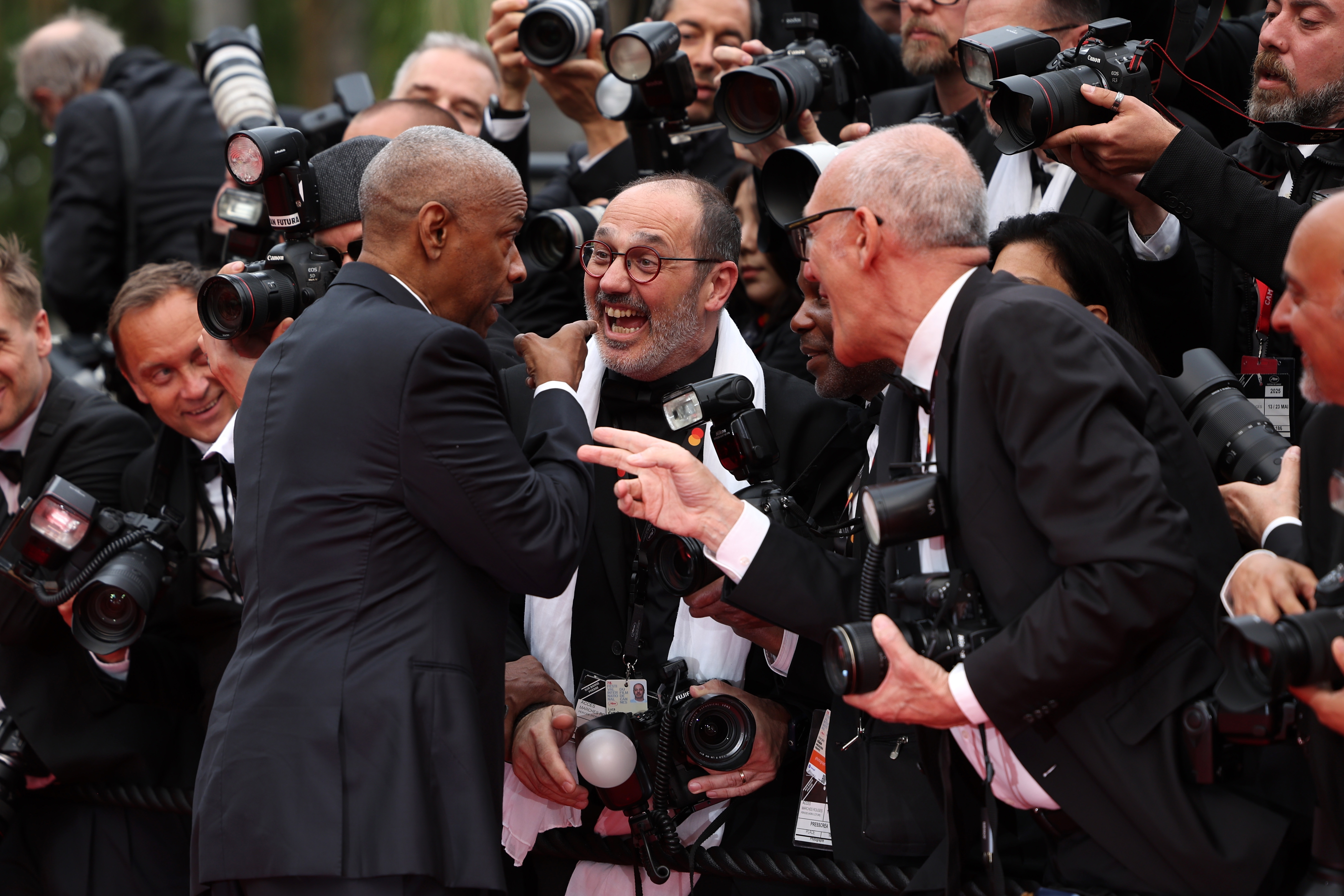 Denzel Washington looking frustrated while confronting with enthusiastic photographers on a red carpet