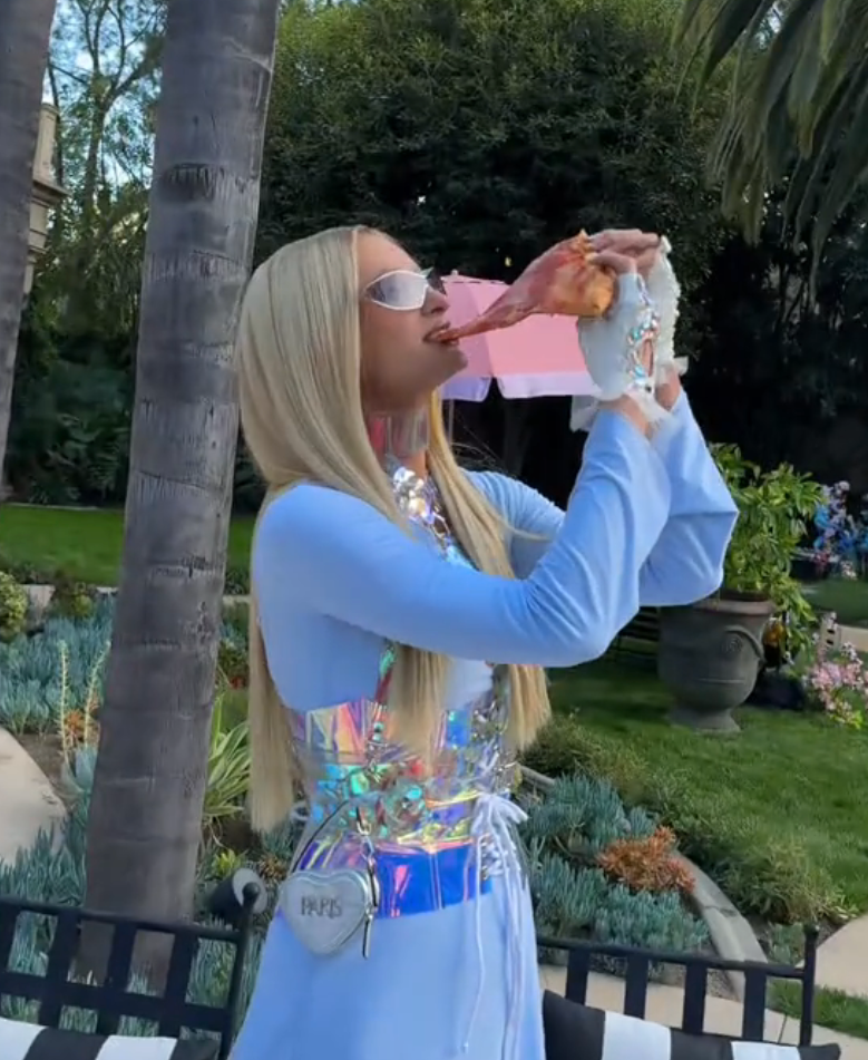 Paris Hilton eating pizza outdoors