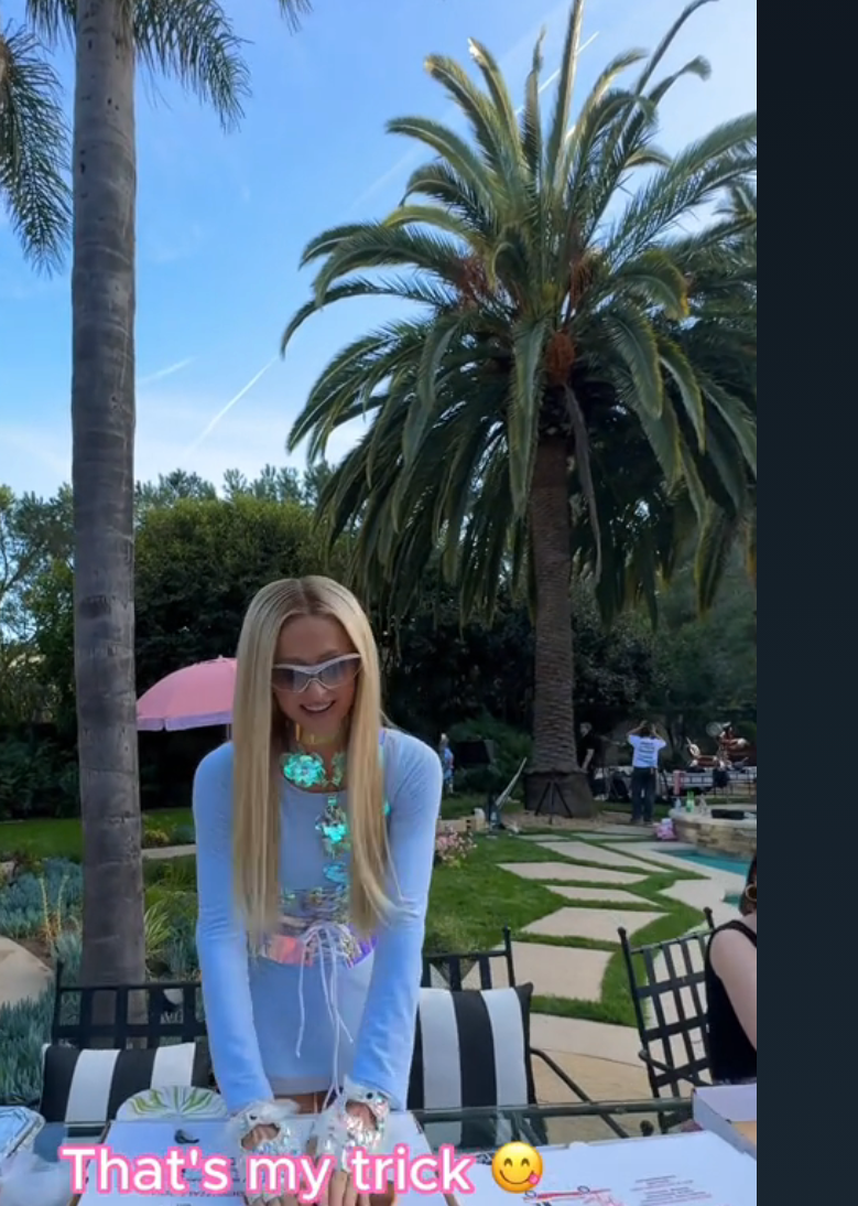 Paris Hilton holding a pizza slice down onto a pizza box with text overlay reading "That's my trick"