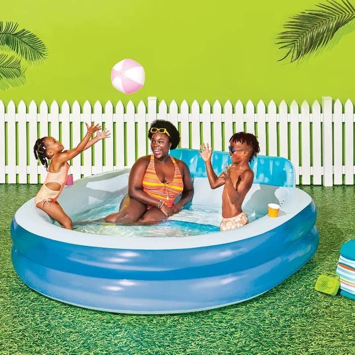 Adults and children play with a formation shot successful an inflatable excavation successful a backyard