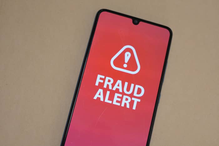 Phone screen displaying "Fraud Alert" with an exclamation mark in a triangle