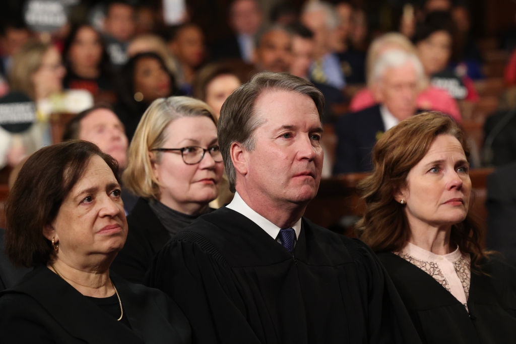 A group of judges seated in a courtroom, dressed in formal judicial robes, attending a significant event or hearing