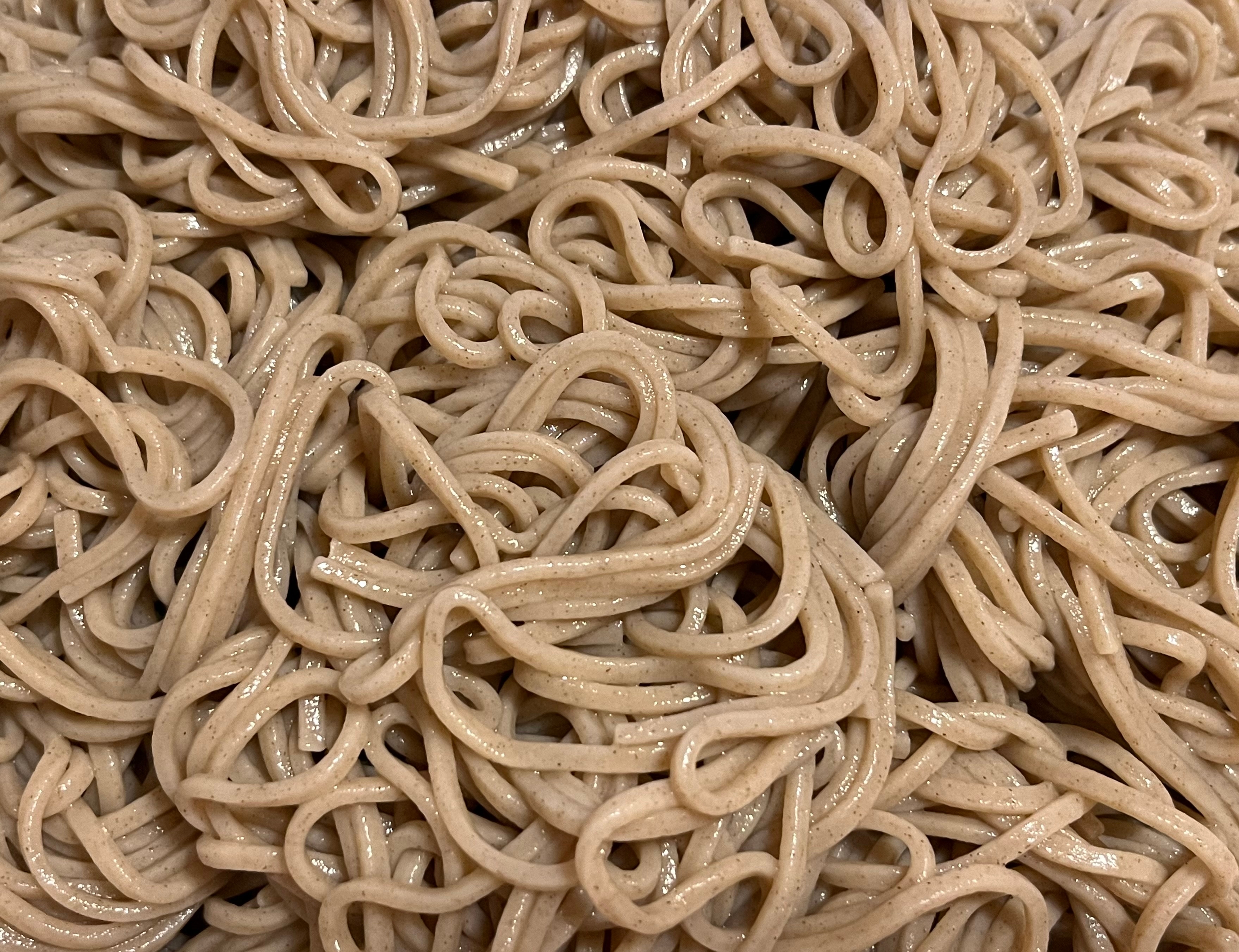 Close-up of cooked whole wheat spaghetti, tangled and glistening