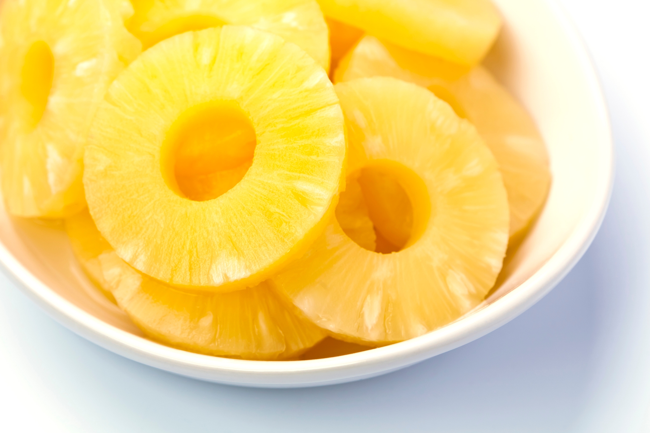 Sliced pineapple rings in a bowl, arranged neatly