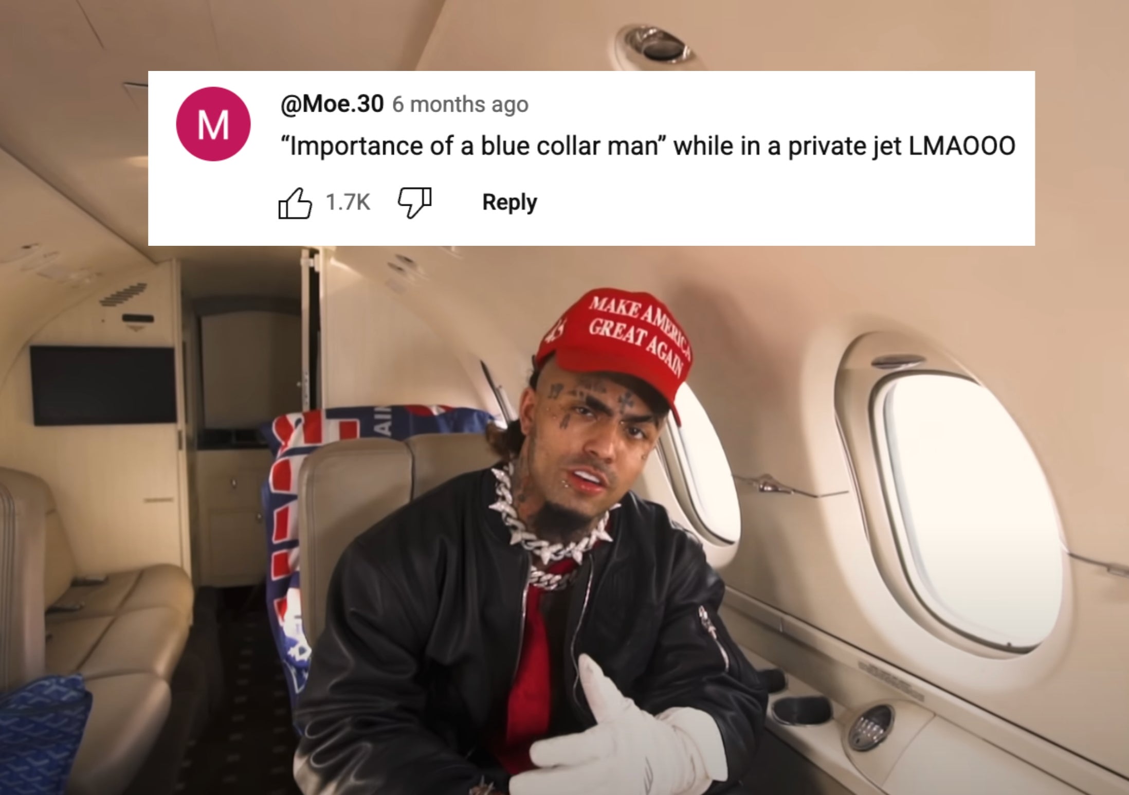 Person sits in private jet wearing a red hat and black jacket, gesturing with gloved hands
