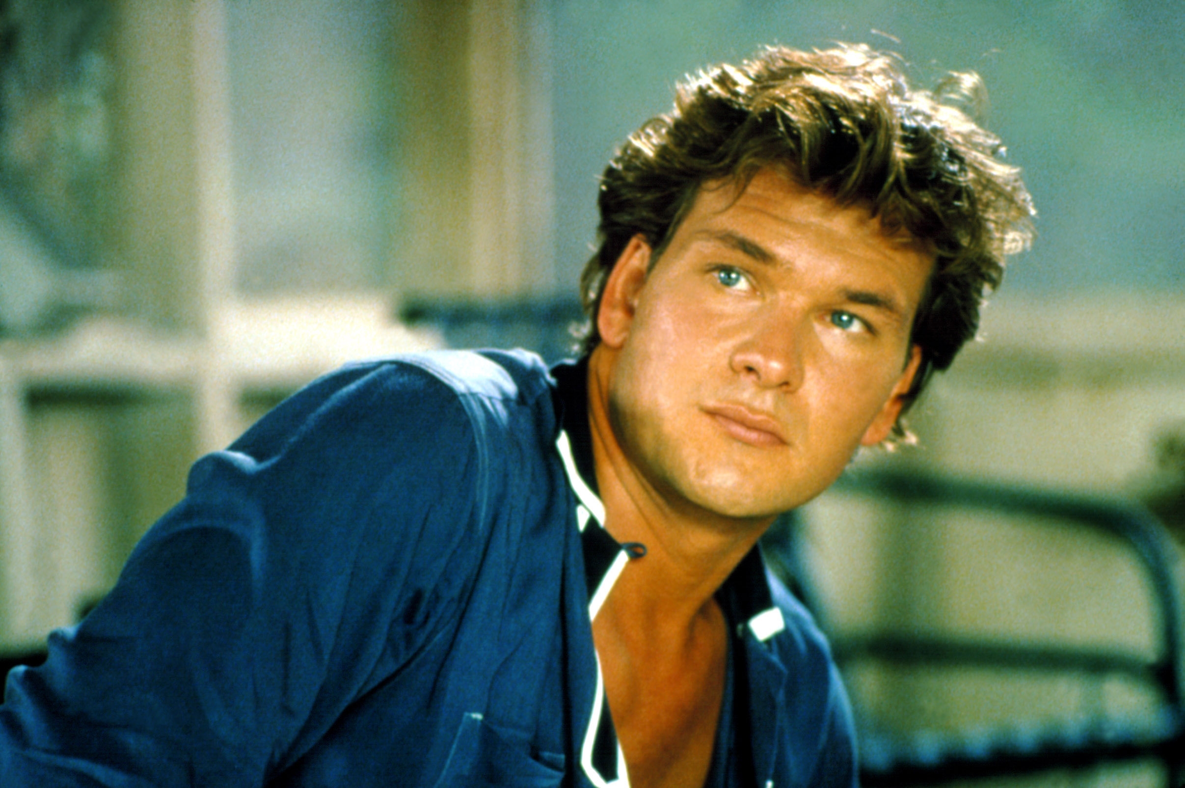 A person in a casual open-collar shirt gazes thoughtfully aside in what appears to be a relaxed setting