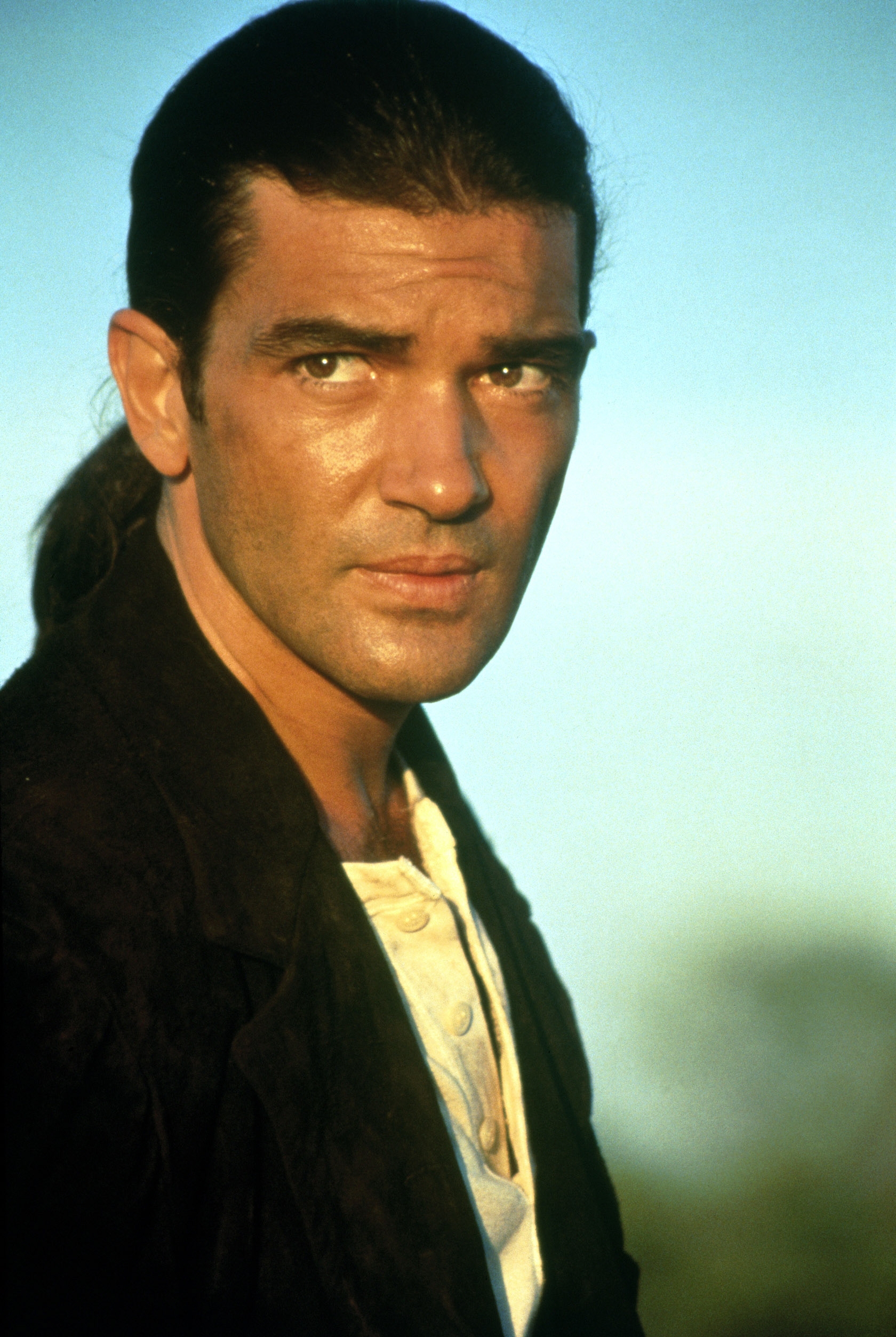 Person with long hair in a relaxed style, wearing casual clothing, looking intently at the camera