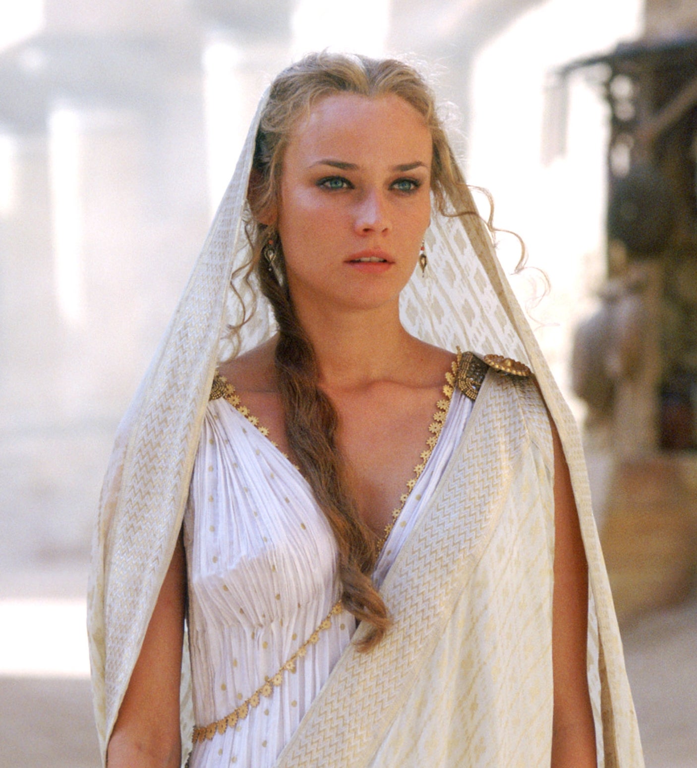 Person in an ancient-themed setting, wearing a draped, Greco-Roman style gown with braided hair, looking thoughtfully ahead