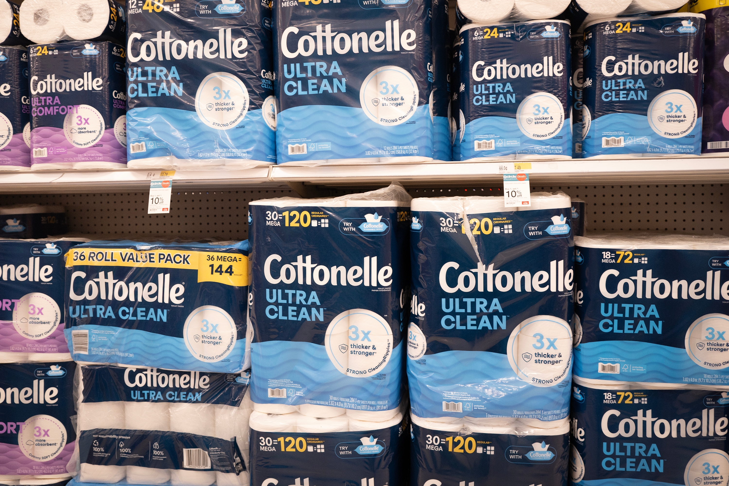Packs of Cottonelle Ultra Clean toilet paper are displayed on a supermarket shelf