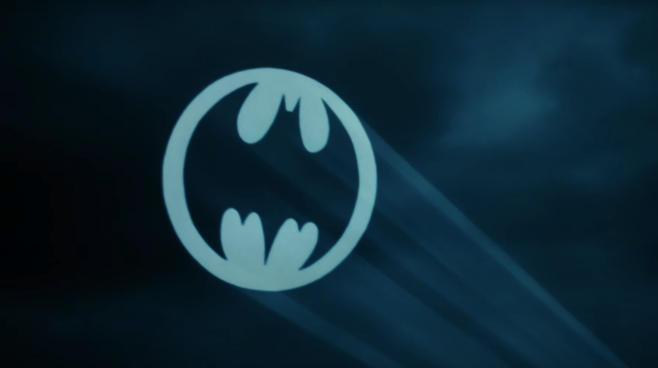 Bat-Signal projected into a cloudy night sky, symbolizing a call for Batman's help