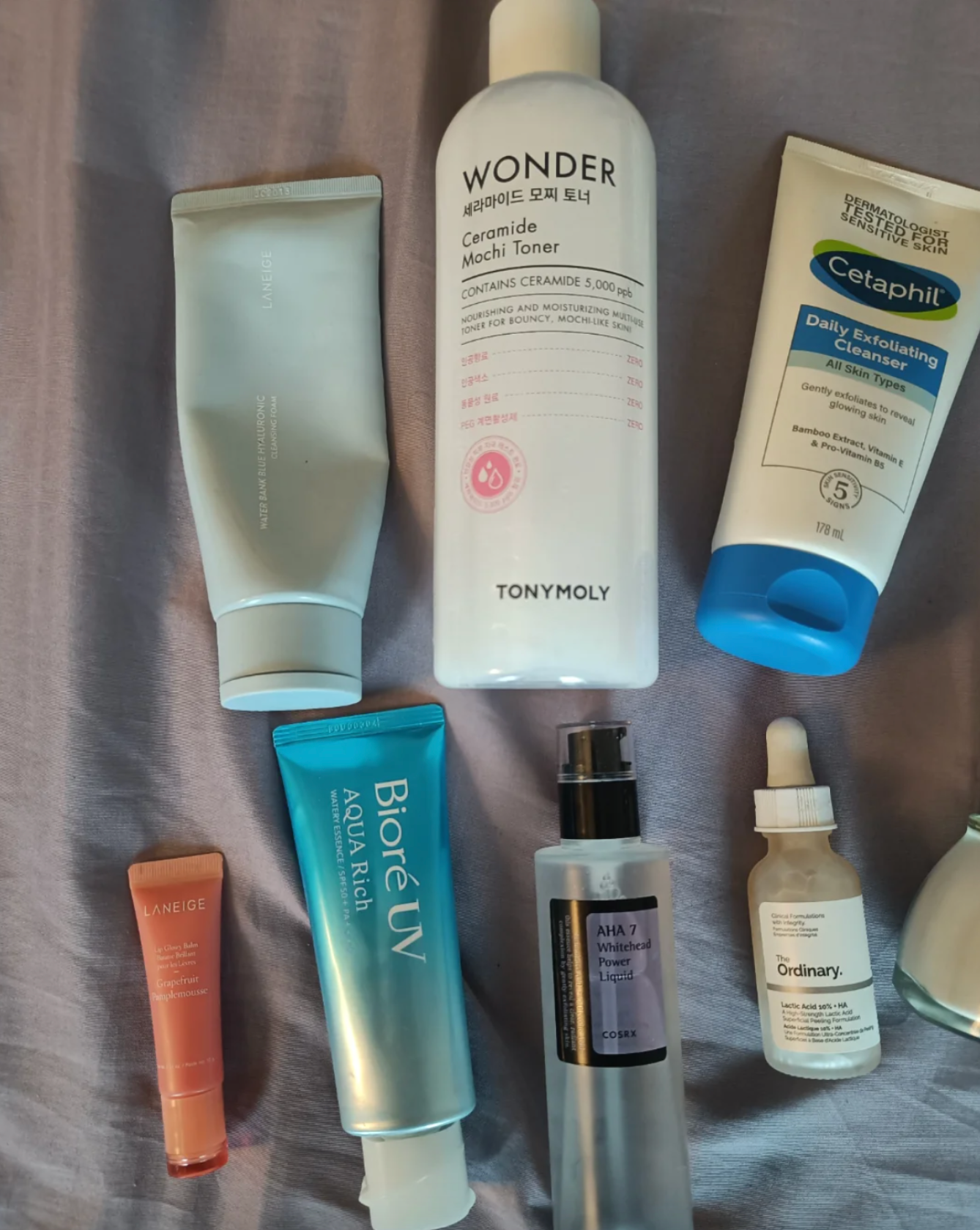 Assorted skincare products including toners, moisturizers, and serums arranged on a surface