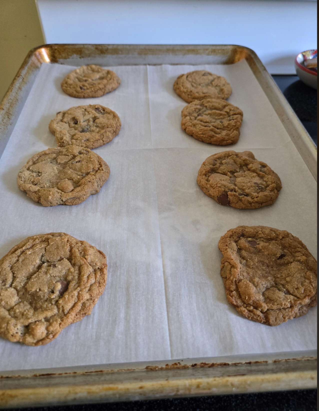 Freshly baked cookies cooling on a parchment-lined baking sheet