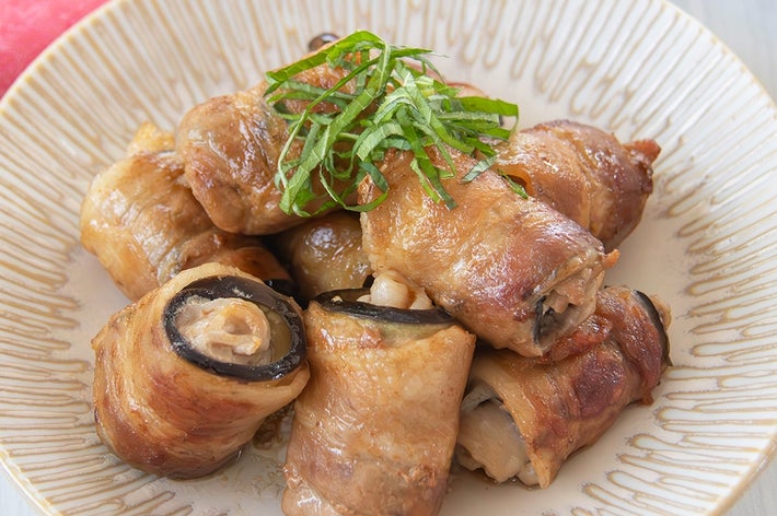 なすと豚バラ肉を巻いて焼いたおかずが皿に盛られている。上には大葉がのっている。