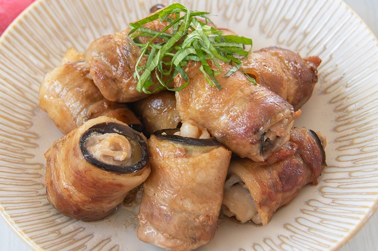 なすと豚バラ肉を巻いて焼いたおかずが皿に盛られている。上には大葉がのっている。