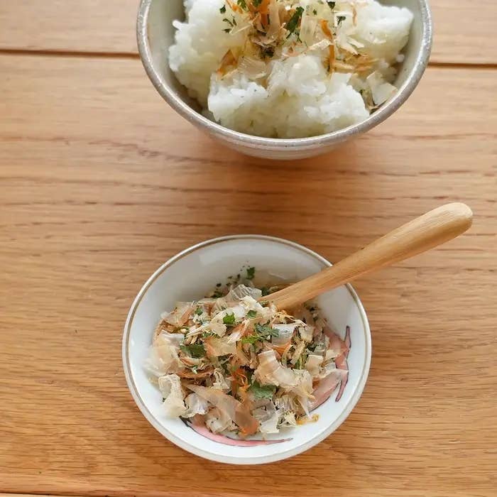ご飯と、小さな皿に盛られたふりかけがあります。